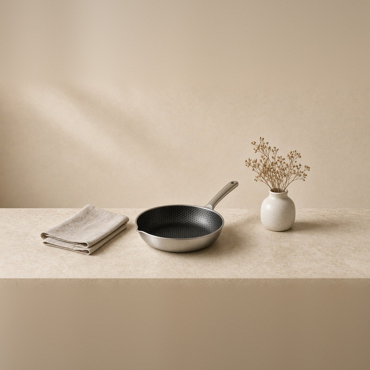 Lifestyle plate — pan with kitchen linen and warm stone.